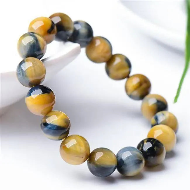 A fantasy tigereye agate bracelet with round beads on a neutral background.
