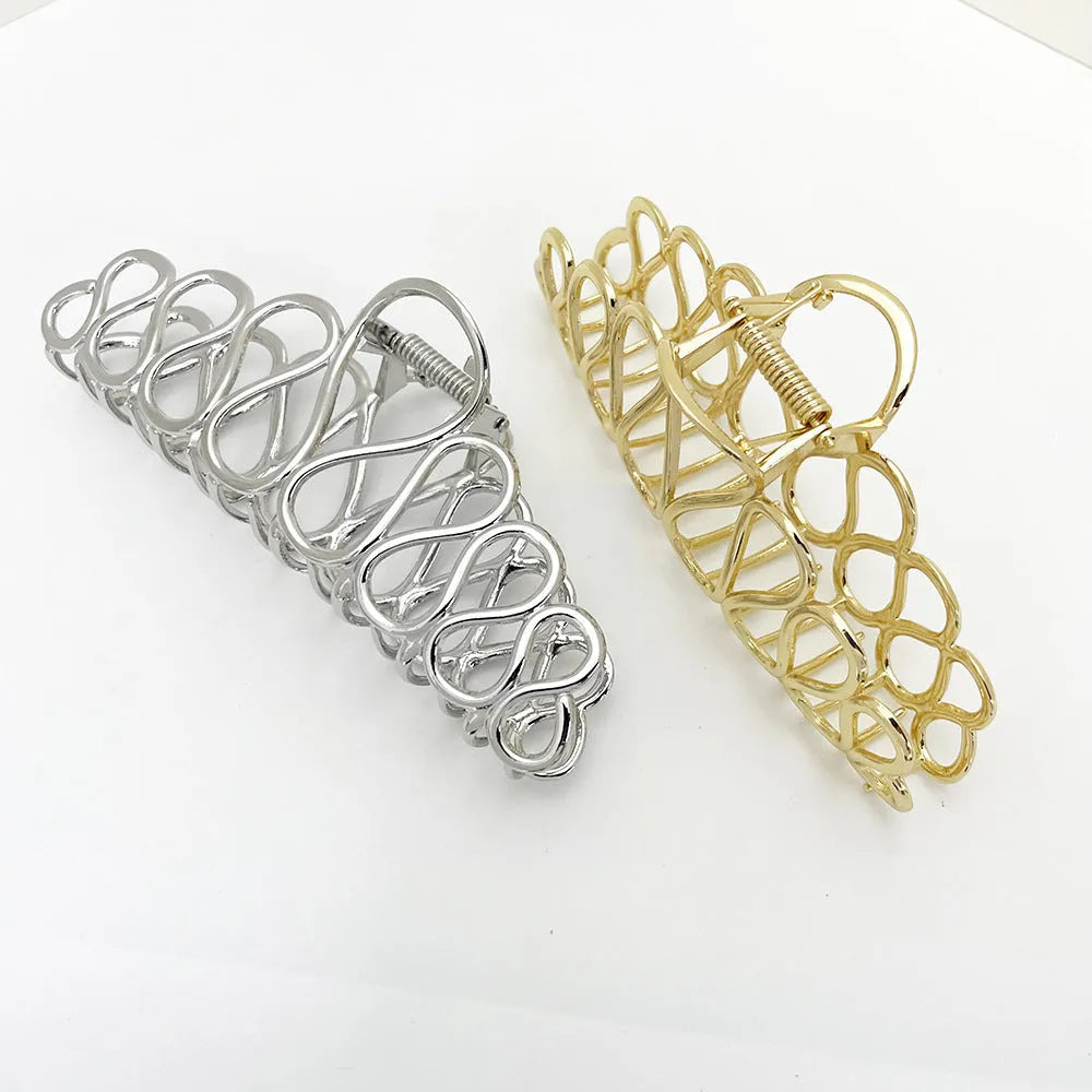 Large minimalist updo hair clip with tassel detail in gold or silver electroplated finish.
