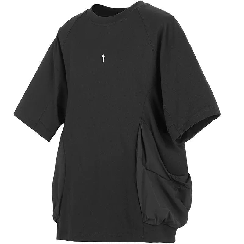 A man wearing a loose grey cotton T-shirt with two large front chest pockets.