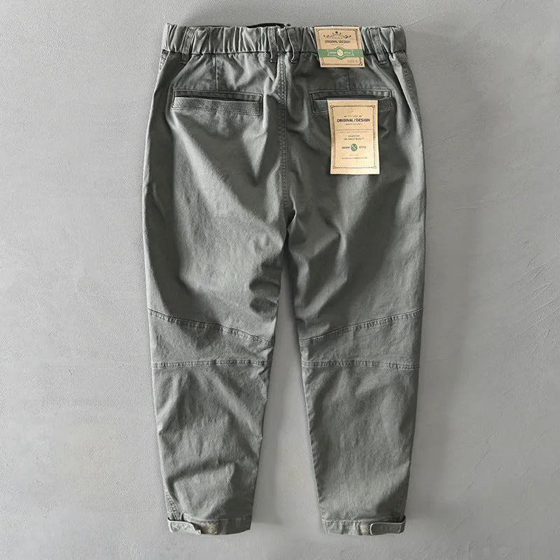 Men's casual overalls in elastic cotton fabric showing loose Japanese-style fit and mid-waist design