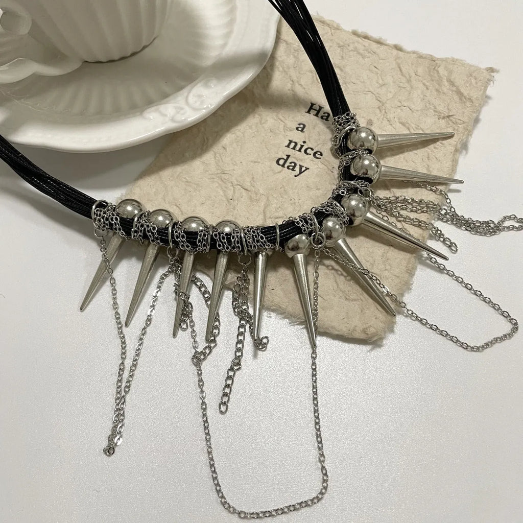 Leather necklace with round beads, a winding tassel, and silver point rivets on a white background.