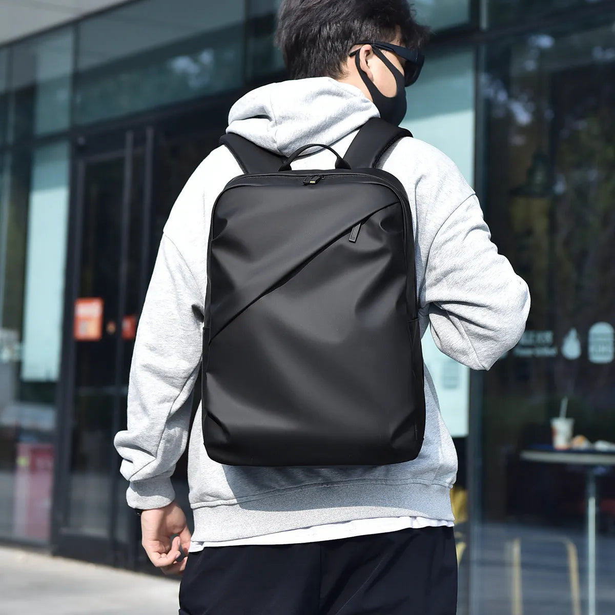 Large waterproof PU leather backpack for men with visible stitching details in black colour