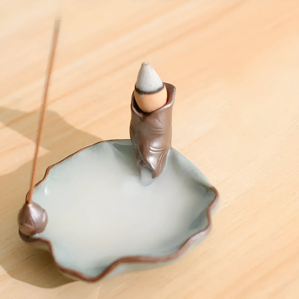 Ceramic reverse flow incense burner with purple clay construction and traditional good luck decorative motifs