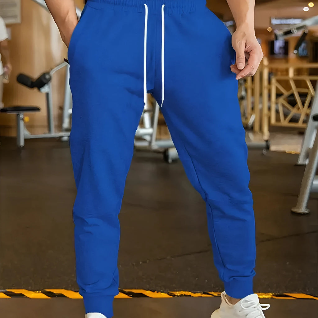 Man wearing loose grey linen-style trousers with an elastic drawstring waist, side view.