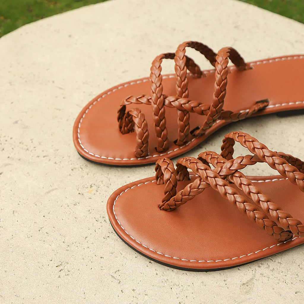 Women's clip-toe flat sandals in black with woven PU upper and rubber sole.