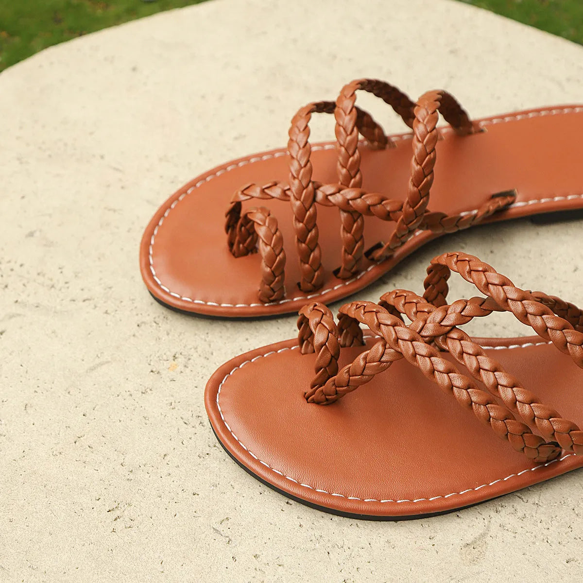 Women's clip-toe flat sandals in black with woven PU upper and rubber sole.