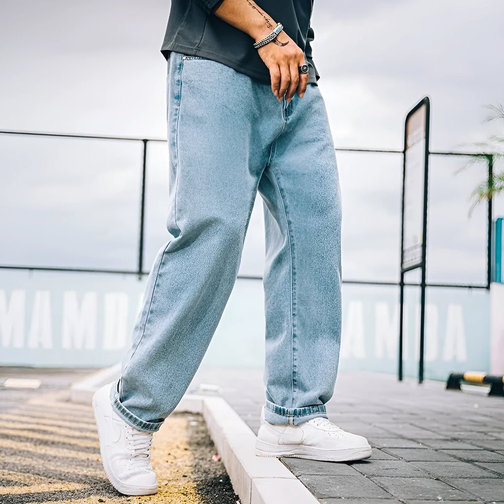 Men's loose straight leg jeans in dark blue cotton denim with a mid-rise waist and zipper fly