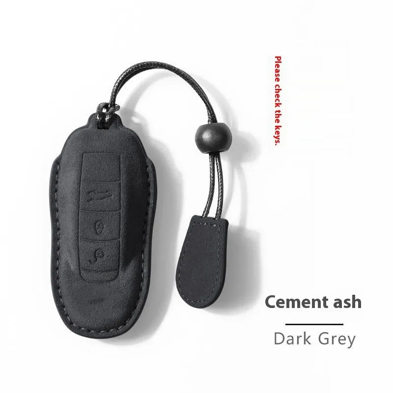 Suede car key cover in cement grey, dark green, light grey, and orange colour options