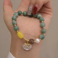 Adjustable green jade bead bracelet with a natural shell clasp fastening.