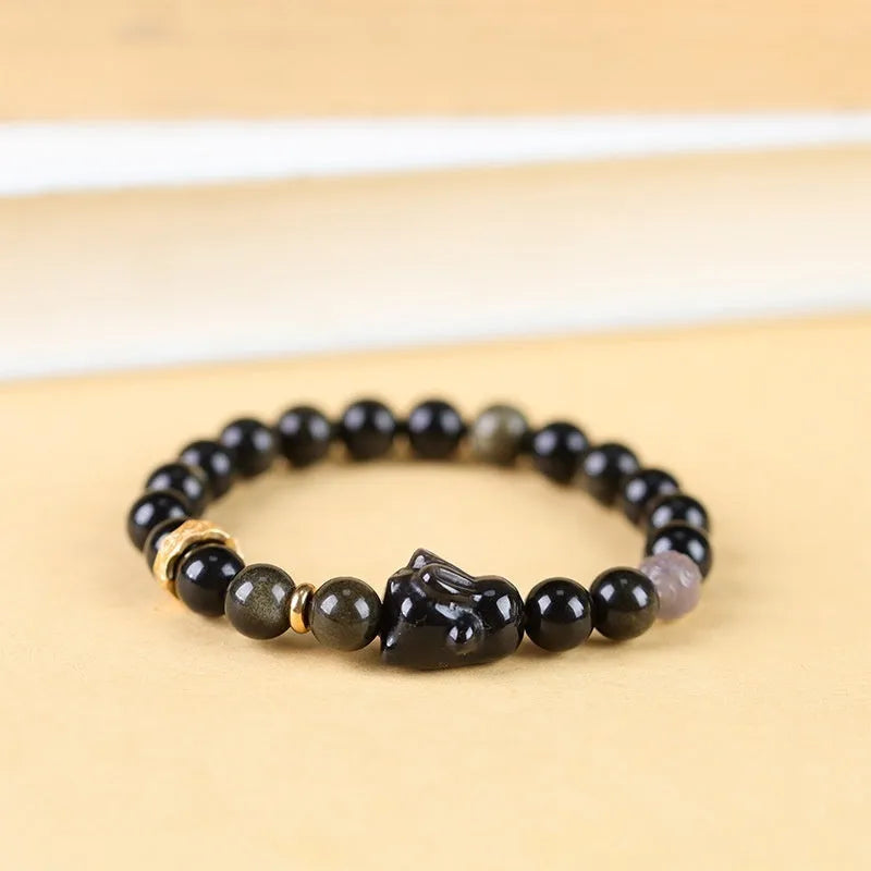 Handmade grey agate and silver lying rabbit charm bracelet on wrist, showing 10mm bead size option.