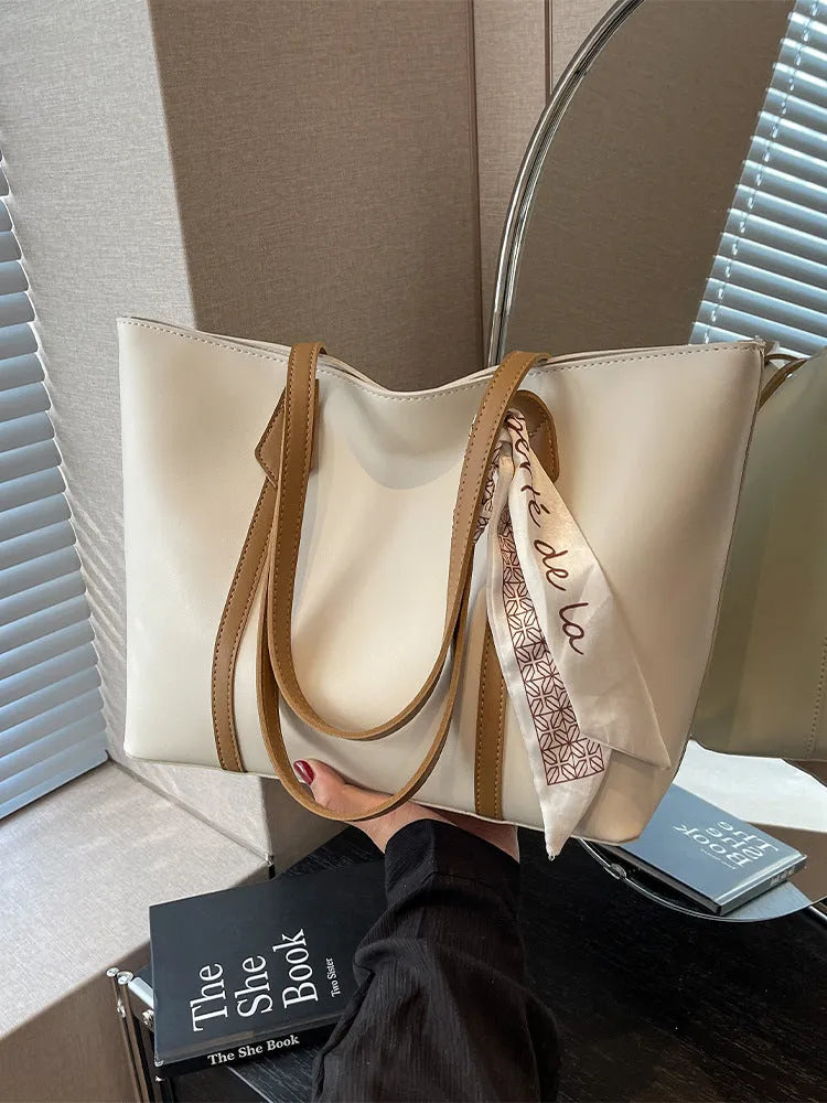 Large soft tote bag in bucket style with crossbody strap and sewing line detailing