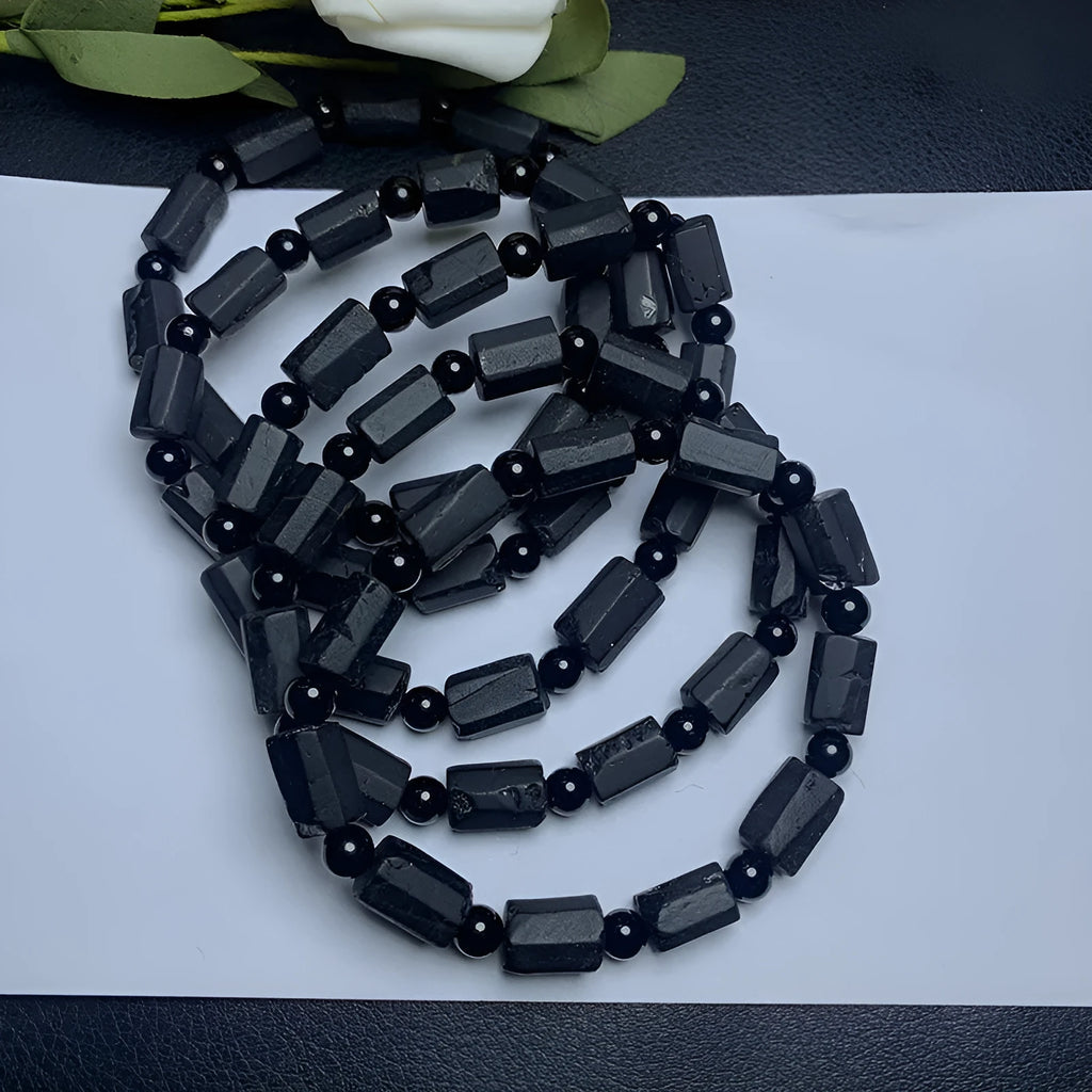 Unisex adjustable bracelet with rough, dark black tourmaline beads on a black cord.
