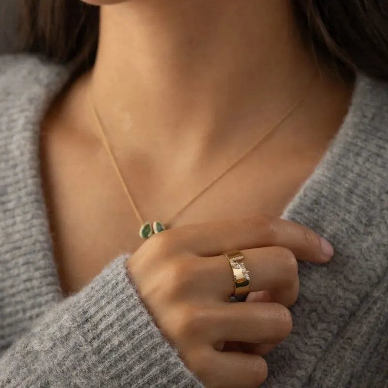 Gold electroplated copper ring for women with shining zircon accents, shown on a finger.