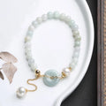 Women's natural emerald peace buckle pearl bracelet with geometric jade pendant on wrist