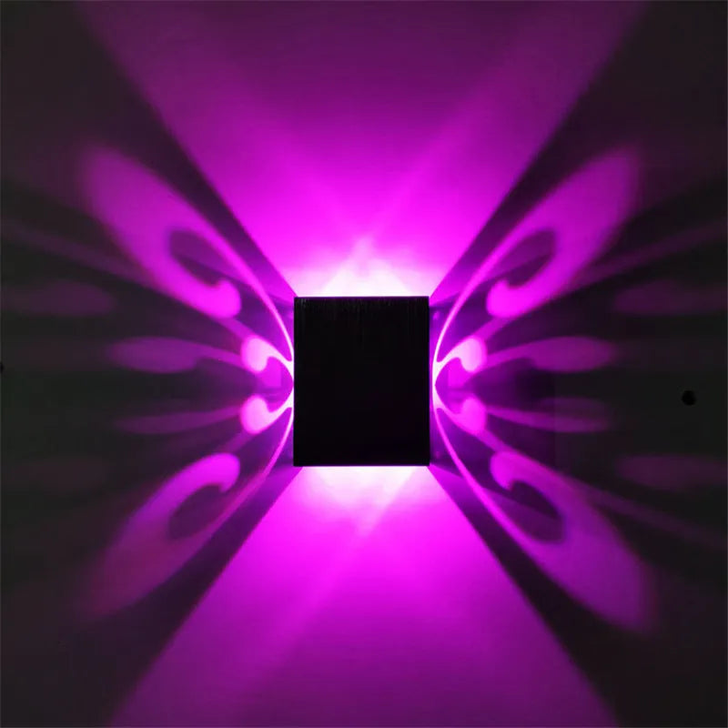 Modern aluminium butterfly-shaped LED wall lamp with remote control on a plain background.
