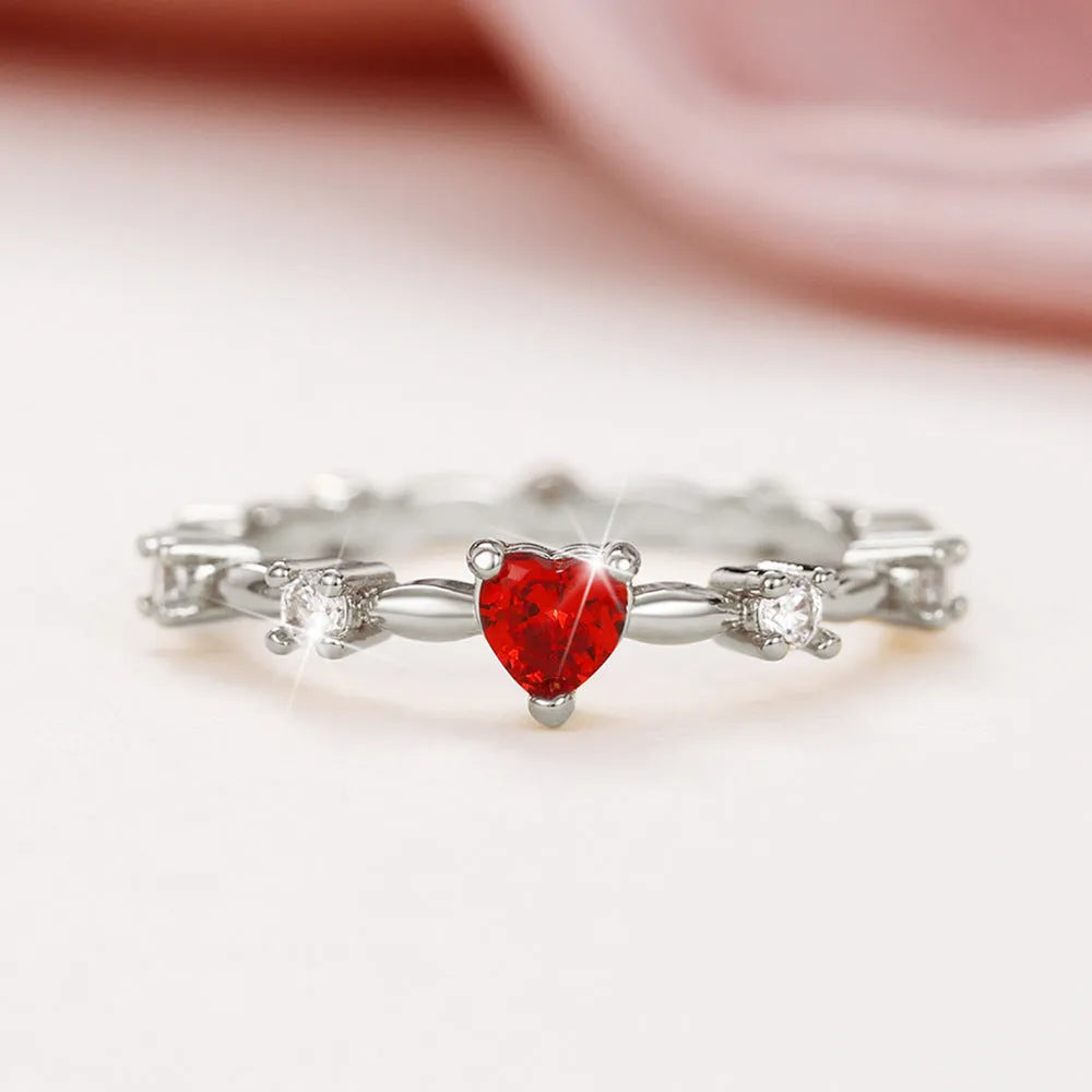 Gold or silver tone peach heart fashion ring with a zircon stone on a model finger.