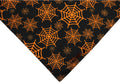 Halloween reversible dog bandana with pumpkin and spider web patterns in black and orange colours