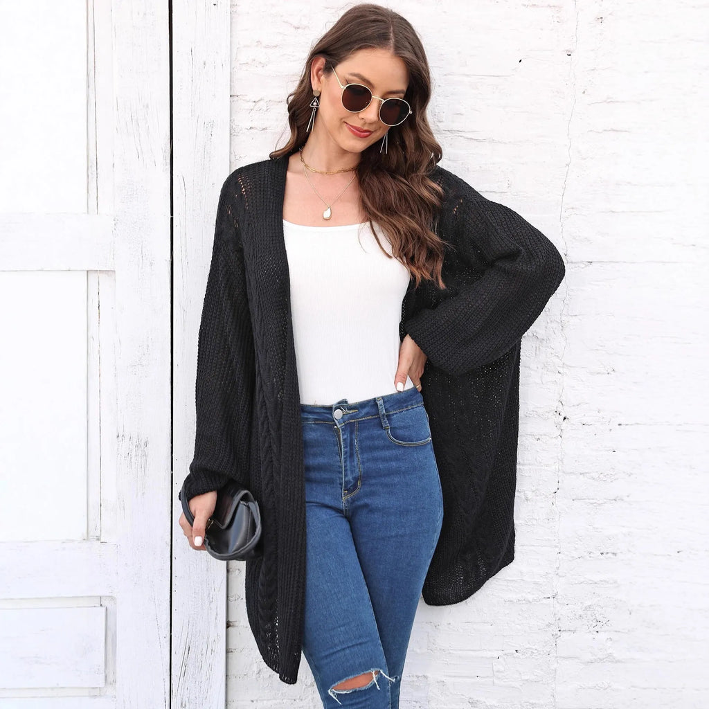 Women's loose-fitting long sleeve acrylic sweater coat in a solid colour on a hanger.