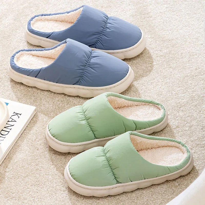 Blue down cotton slippers with artificial leather upper, thick rubber sole, and plush lining shown on a wooden floor.