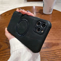 Black imitation leather magnetic charging case for Apple iPhone on a wireless charger.