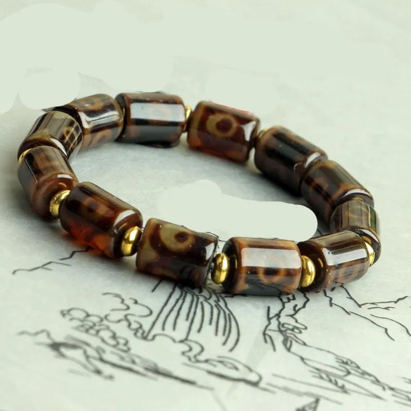 Distressed agate bracelet with traditional Tibetan dzi beads including three-eye and Nine Eyes designs.