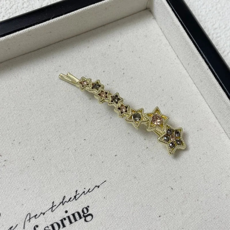 Gold electroplated hair barrette with star decoration and side clip design for bangs