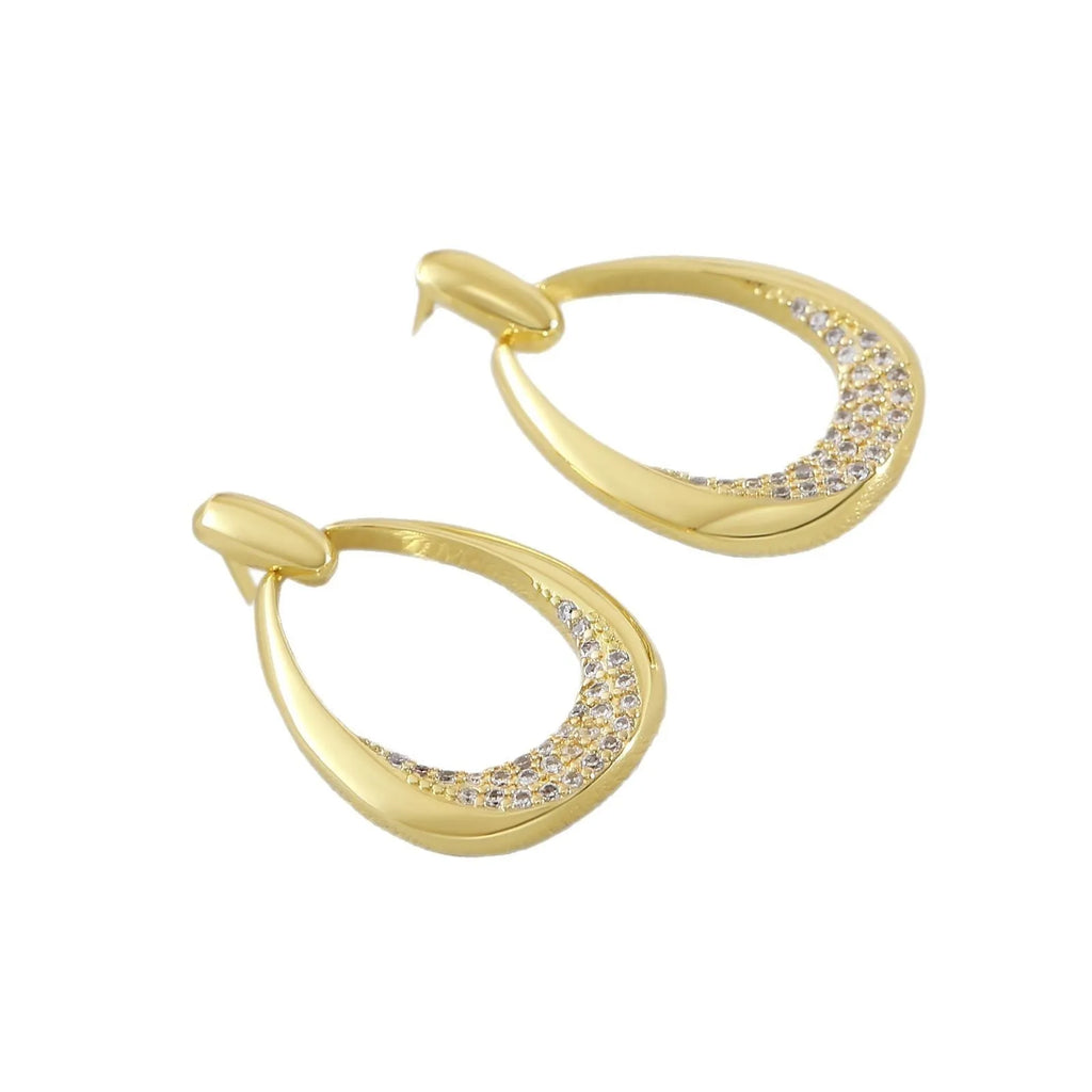 Yellow gold geometric drop earrings with round and oval ring elements on white background