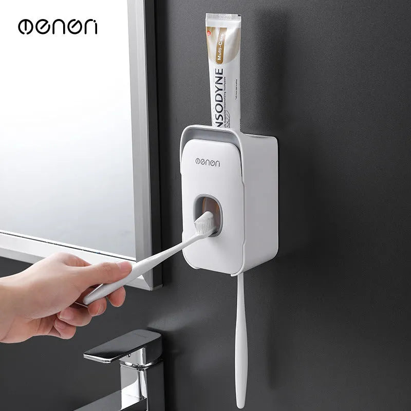 A blue automatic toothpaste dispenser mounted on a bathroom wall with a soft-touch button.