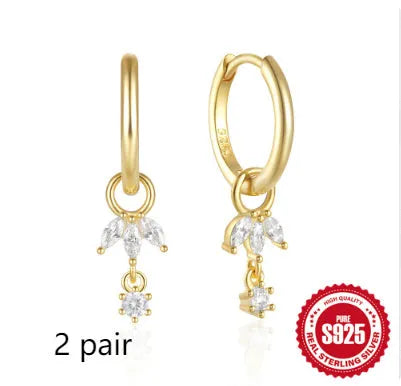 Golden coloured geometric sunflower sterling silver earrings with zircon inlay on a white background.