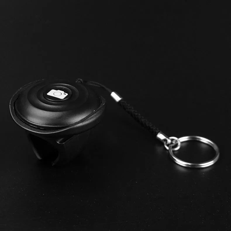 Black Snap Bluetooth remote control for wireless smartphone and camera photos.