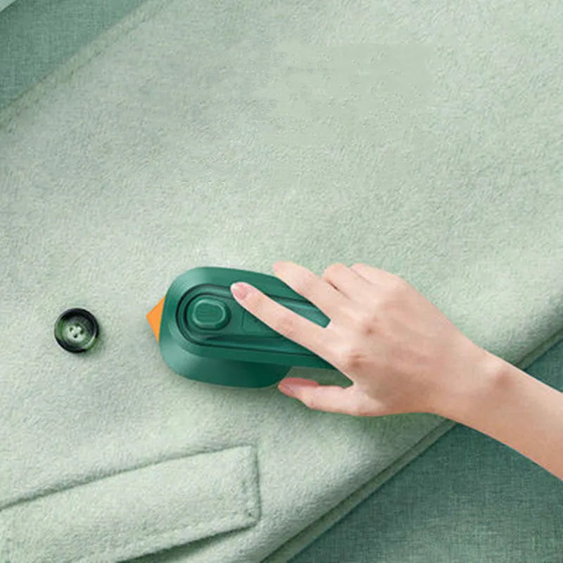Dark green hand-held steam iron with ceramic panel showing dual temperature buttons and compact design