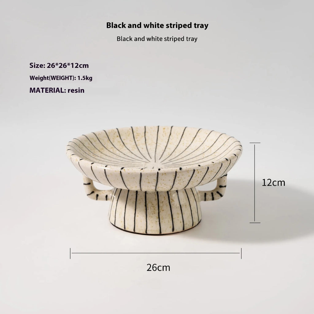Black and white striped synthetic resin dessert plate on a table.