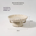 Black and white striped synthetic resin dessert plate on a table.