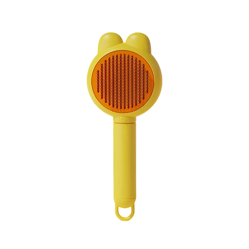 Green self-cleaning pet grooming brush with metal comb and comfort-grip handle on a wooden table.
