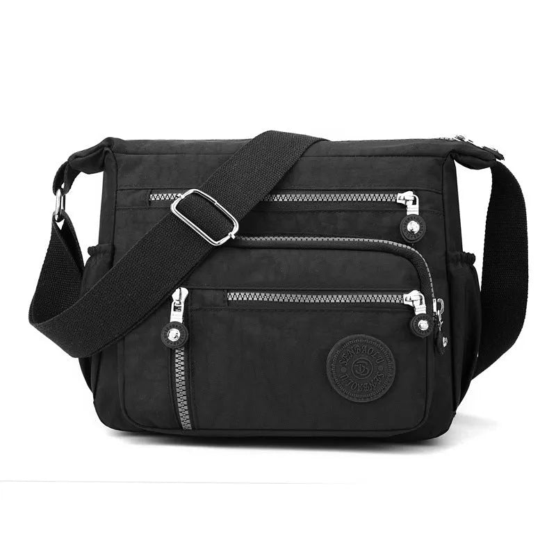 Grey nylon messenger bag with single shoulder strap showing square vertical shape and lining interior