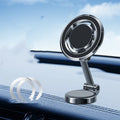 Black car phone holder with magnetic clip fixation mounted on instrument panel showing 360-degree rotation