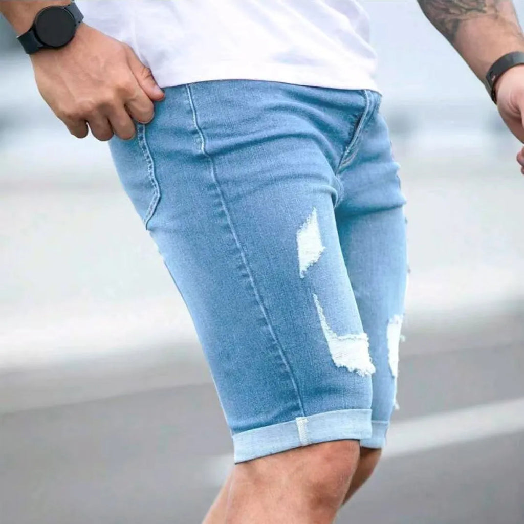Sky blue men's denim shorts with distressed holes, low waist, and straight leg.