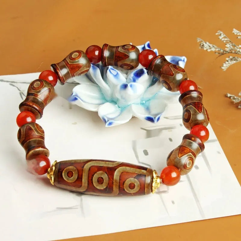 Distressed agate bracelet with traditional Tibetan dzi beads including three-eye and Nine Eyes designs.