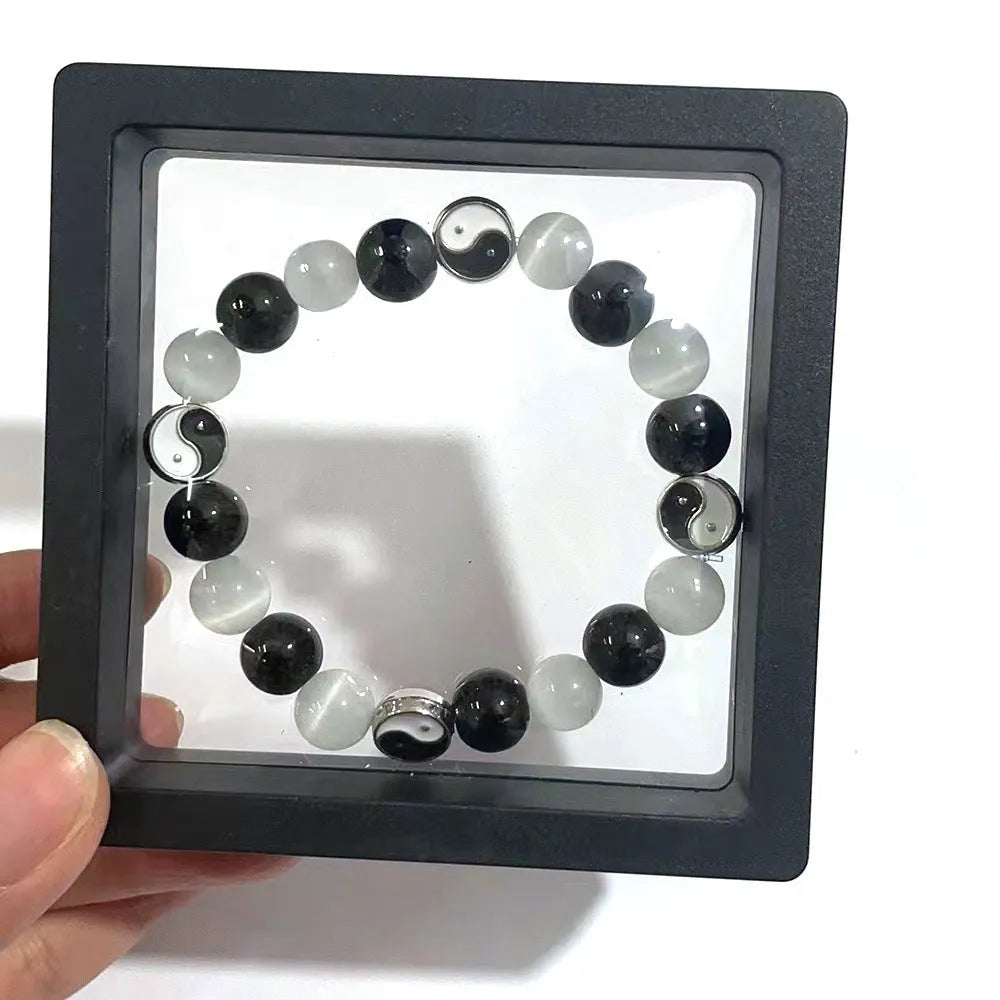 Close-up of a natural opal Tai Chi beaded bracelet with 10mm polished stones on a wrist.