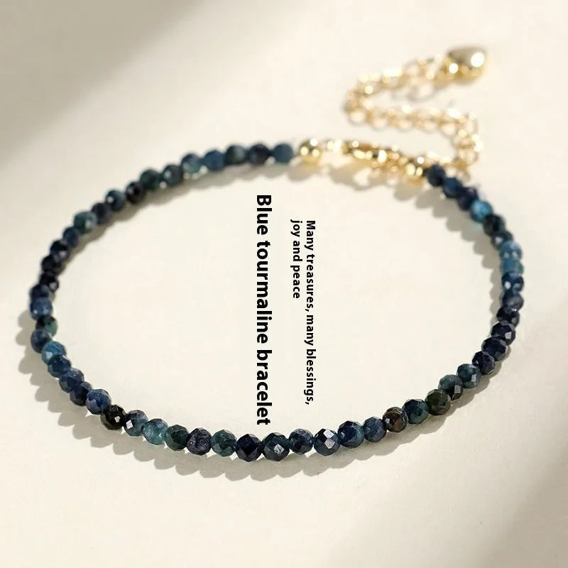 Blue tourmaline bracelet with 3mm beads and spacer beads on a wrist.