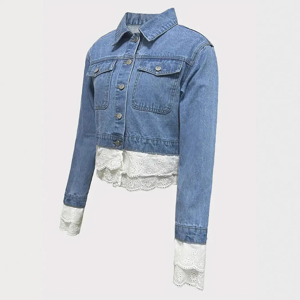 Blue women's denim jacket with lace stitching detail on front, long sleeves, shown on hanger