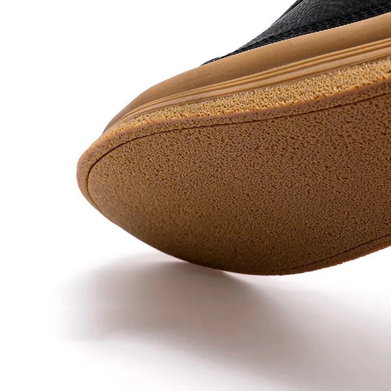 Men's black leather casual shoes with round toe, flat heel, and white rubber sole on a plain background.