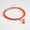 Hand-woven ethnic bracelet with natural red agate beads in diamond shapes showing woven pattern detail
