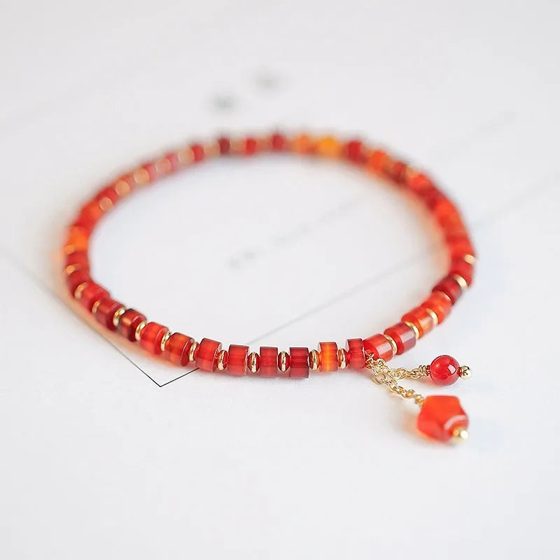 Hand-woven ethnic bracelet with natural red agate beads in diamond shapes showing woven pattern detail