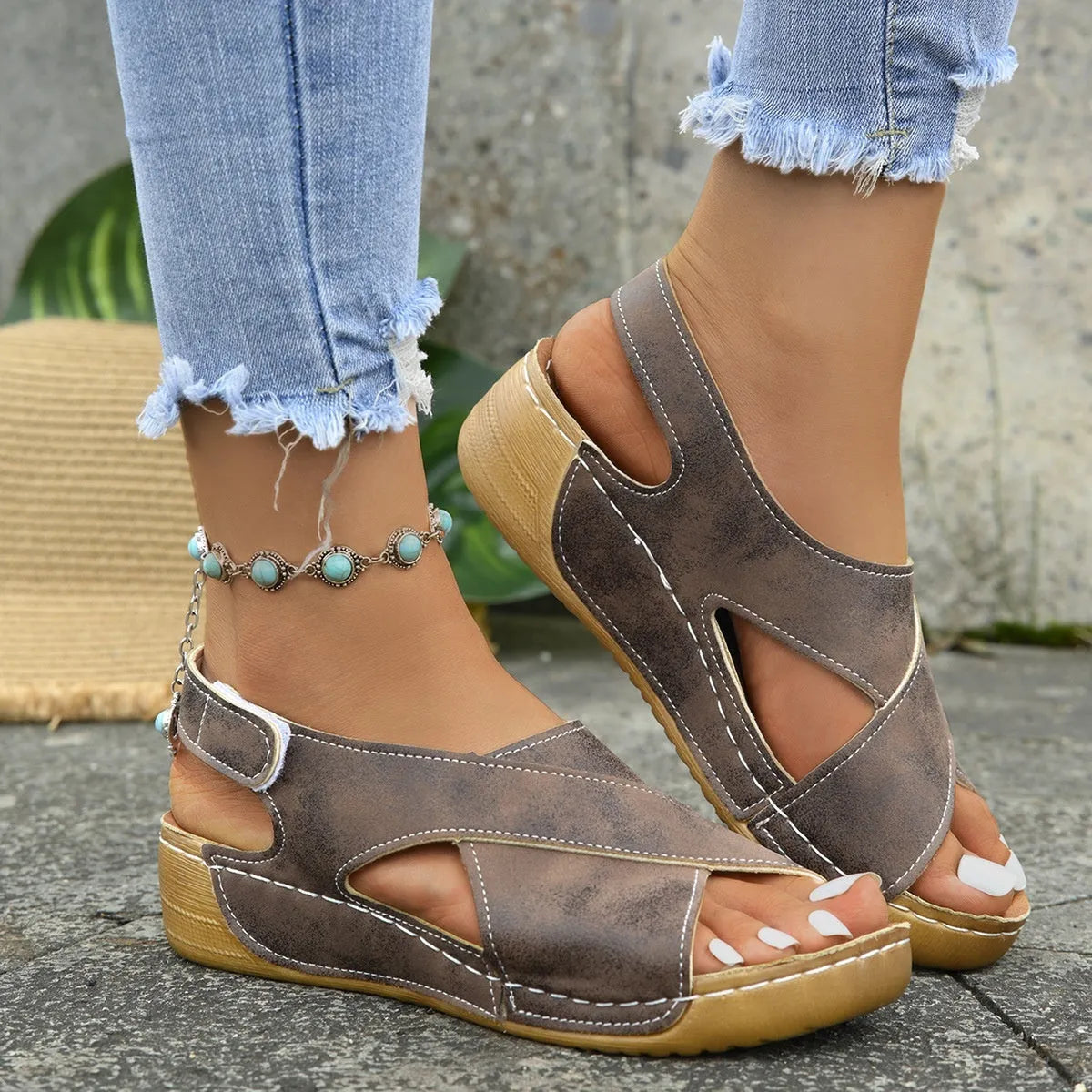 Women's beige Roman-style sandals with a fabric skirt detail, platform sole, and Velcro strap.