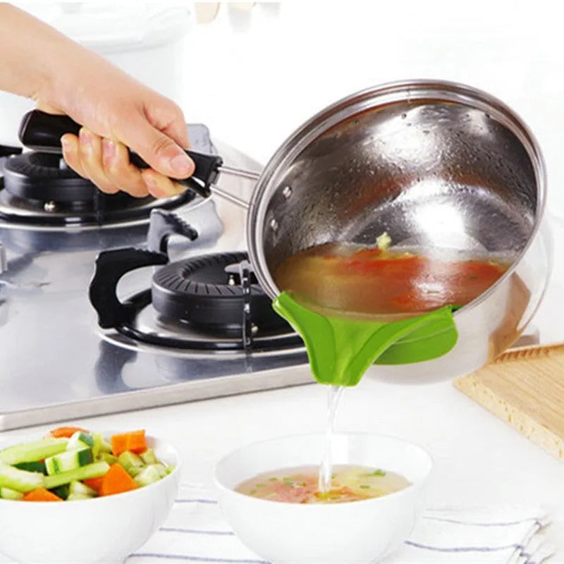 Green silicone soup funnel, 12 x 3 x 4.5 cm, clipped to edge of round pot for pouring