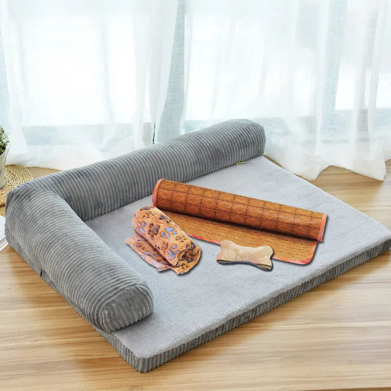 Corduroy pet sofa dog bed with a raised bolster, shown in a grey colour on a wooden floor.