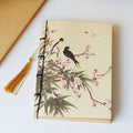 A5 antique wire-bound notebook with glossy embossed cover featuring a retro painting design, shown open.