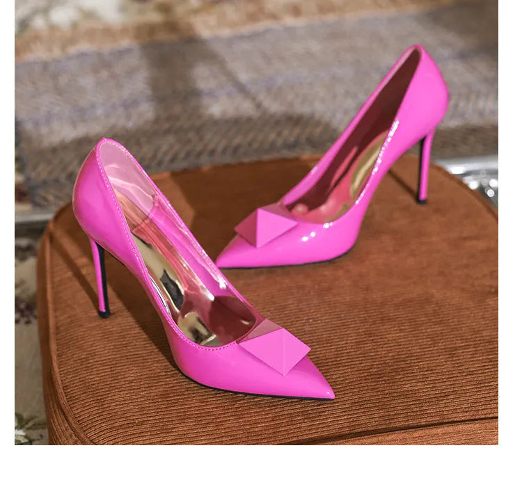 Pink patent leather women's stiletto heels with pointed toe and rivet buckle fastening