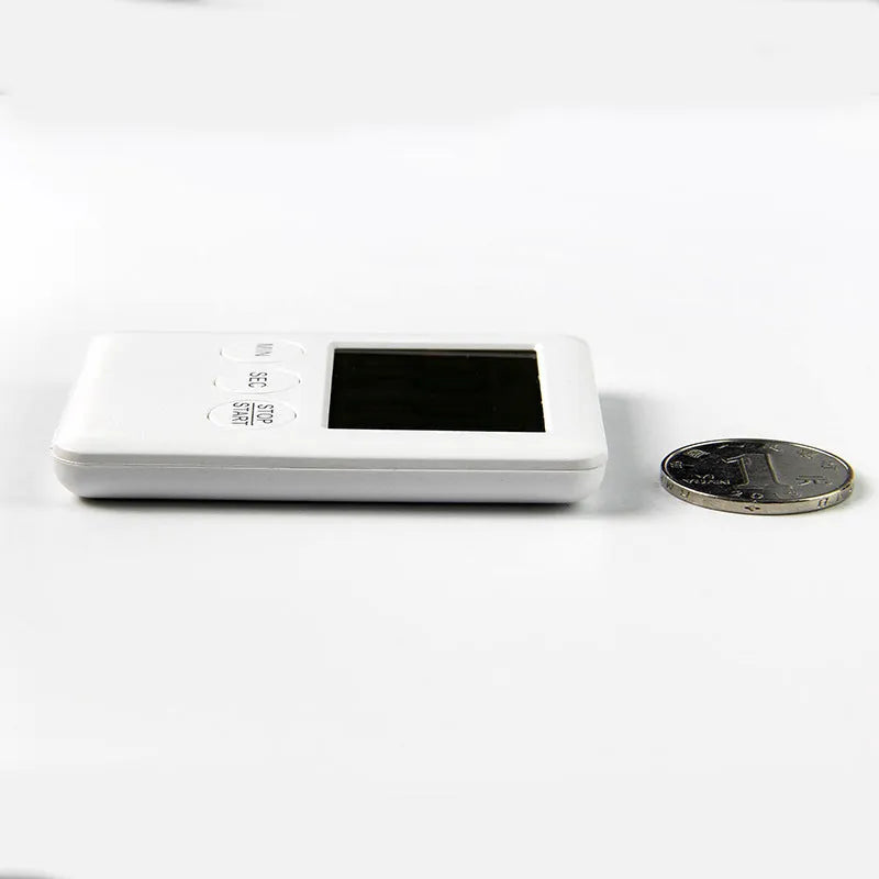 Black and white digital kitchen timer with magnet back on a refrigerator